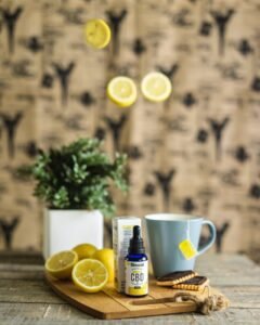 white ceramic mug with sliced lemon beside white ceramic mug on brown wooden table